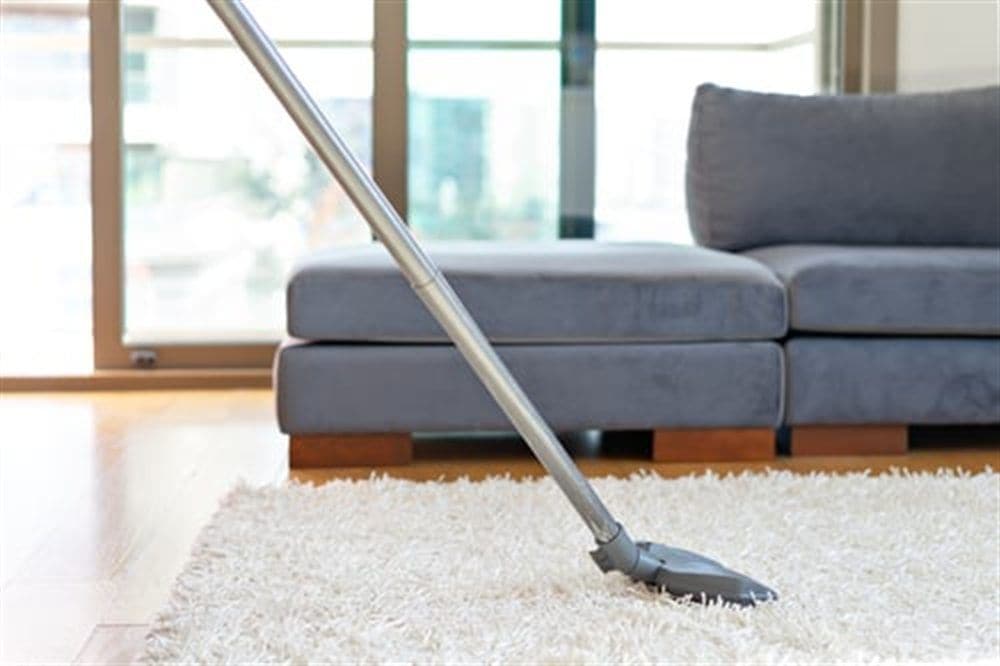 Living room carpet being vacuumed during an AHC residential cleaning visit