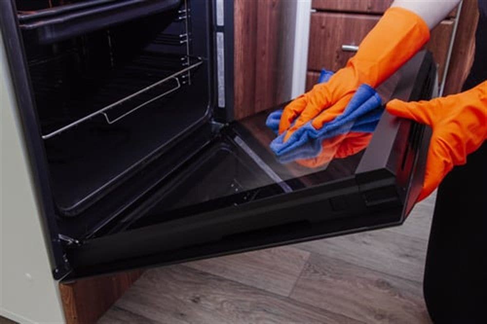 AHC cleaner deep cleaning an oven interior during a residential deep clean in McHenry County